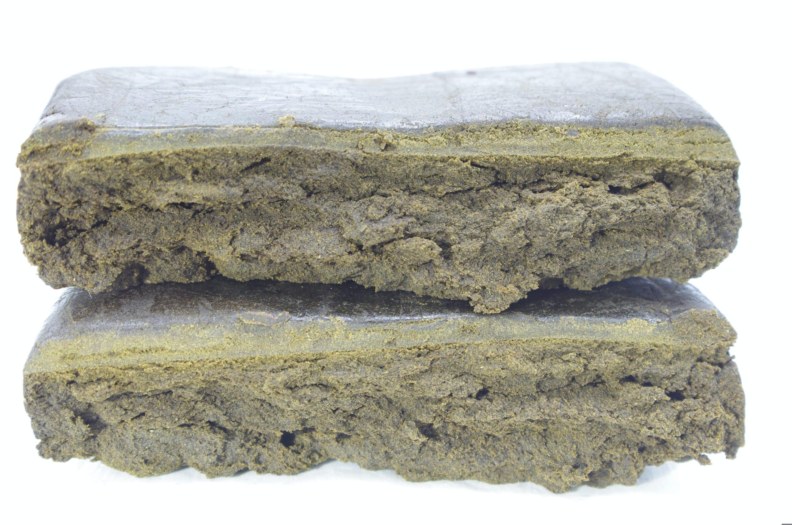 Blueberry Hash Two rectangular pieces of compressed material stacked horizontally, showing a layered interior texture and slightly rough surface on a plain background.