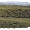 Two rectangular pieces of compressed material stacked vertically, showing a dense, layered interior texture on a plain background.