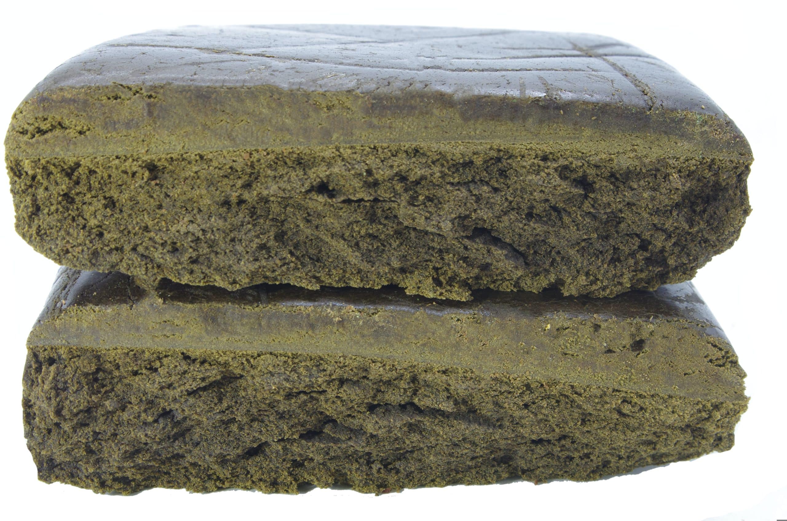 Pakistani Hash Two rectangular pieces of compressed material stacked vertically, showing a dense, layered interior texture on a plain background.